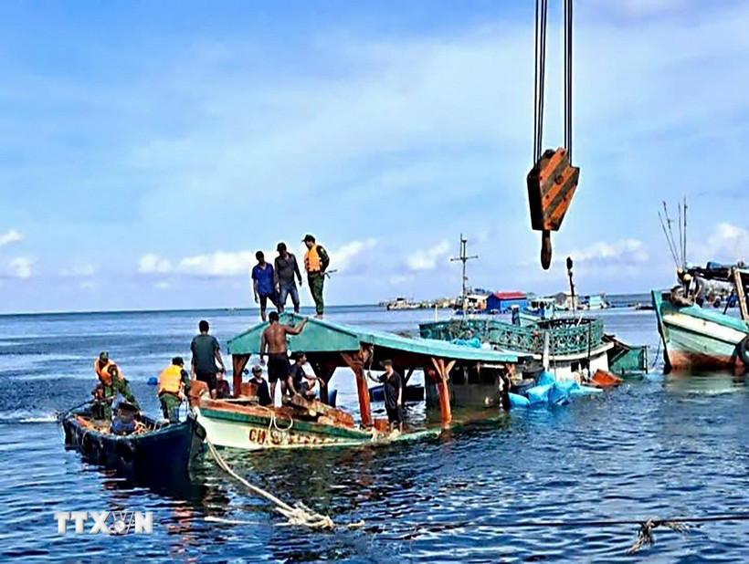 Tàu cá CM 91554 TS bị nạn trên biển được các lực lượng và nhân dân hỗ trợ lai dắt vào bờ. (Ảnh: TTXVN phát)