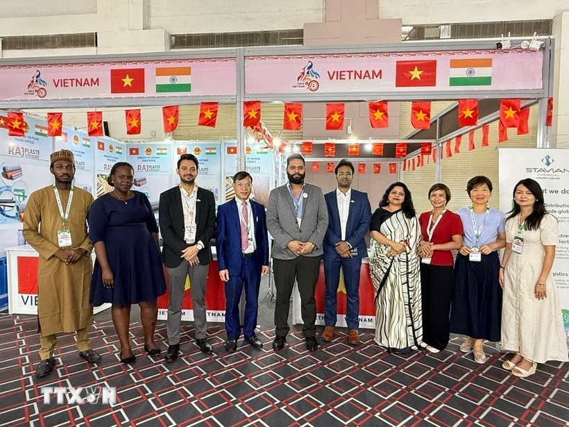 Tham tán Thương mại Bùi Trung Thướng (thứ 4 từ trái sang) chụp ảnh lưu niệm của các quan khách trong và ngoài nước tới tham quan gian hàng. (Ảnh: Ngọc Thúy/TTXVN)