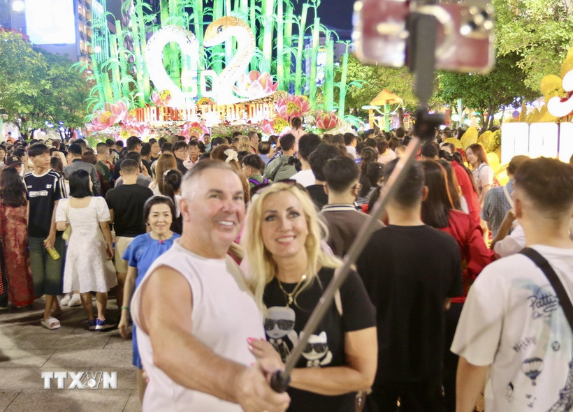 Người dân và du khách chuẩn bị đón Giao thừa năm Ất Tỵ 2025 tại đường hoa Nguyễn Huệ (Quận 1). (Ảnh: Thanh Vũ/TTXVN)