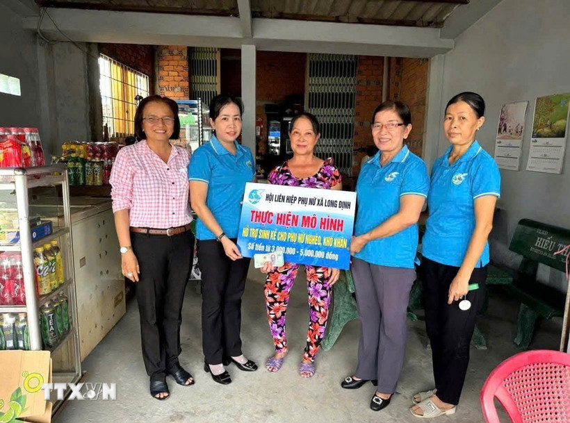 Chị Đặng Thị Huê, vượt khó nuôi con học đại học, nhận vốn cho vay của Hội Liên hiệp Phụ nữ xã Long Cang, tỉnh Tây Ninh. (Ảnh: Đức Hạnh/TTXVN)