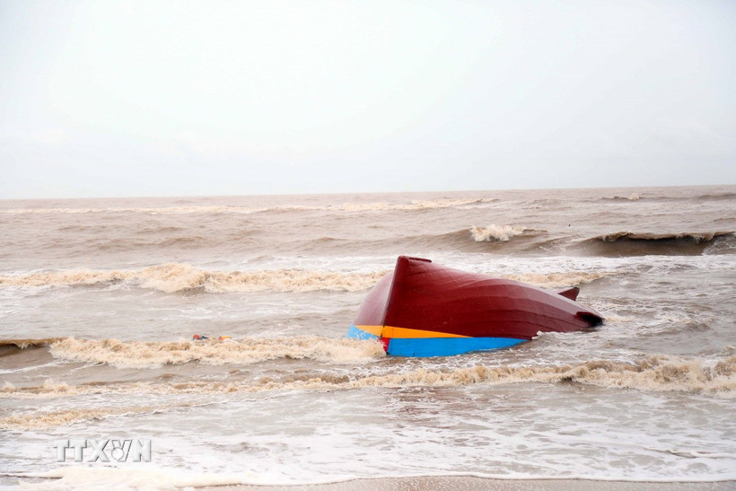 Một tàu cá bị lật úp, dạt vào bờ biển, cách khu vực cảng Gianh (xã Bắc Trạch, Quảng Trị) khoảng gần 3km. (Ảnh: Tá Chuyên/TTXVN)