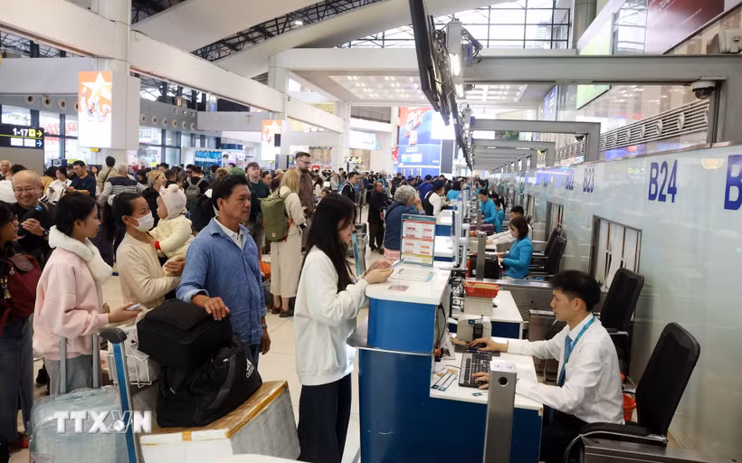 Hành khách xếp hàng làm thủ tục tại sân bay Nội Bài. (Ảnh: Quốc Khánh/TTXVN)