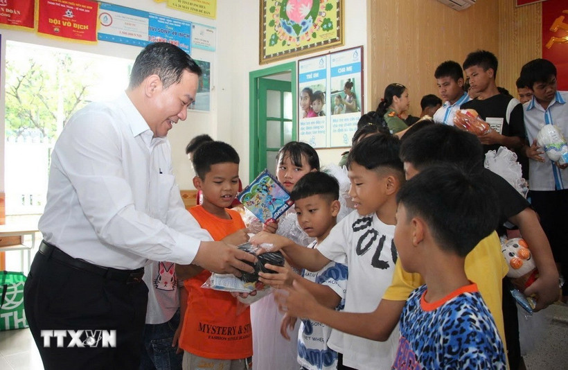 Phó Giám đốc Sở Y tế Khánh Hòa Trịnh Ngọc Hiệp trao quà cho trẻ em đang sinh sống tại Trung tâm Bảo trợ và Công tác xã hội tỉnh Khánh Hòa. (Ảnh: TTXVN phát)