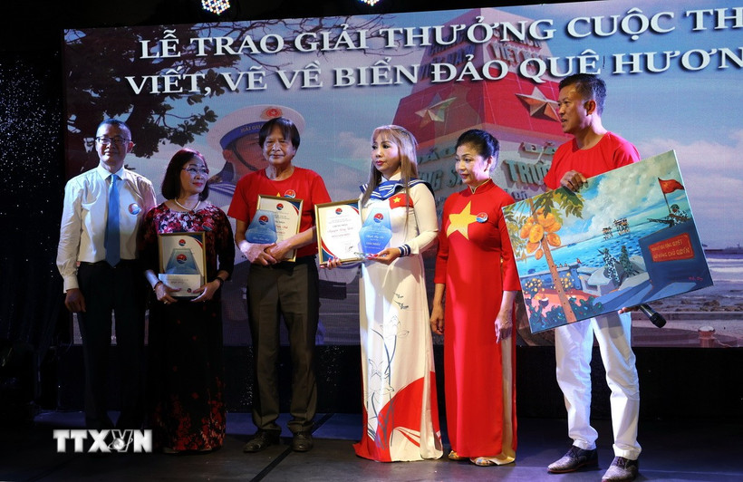 Đại sứ Vũ Quang Minh (ngoài cùng bên trái) trao Giải Nhất cho ba thí sinh dự thi ở các thể loại văn xuôi, thơ và tranh vẽ. (Ảnh: Thu Hằng/TTXVN)