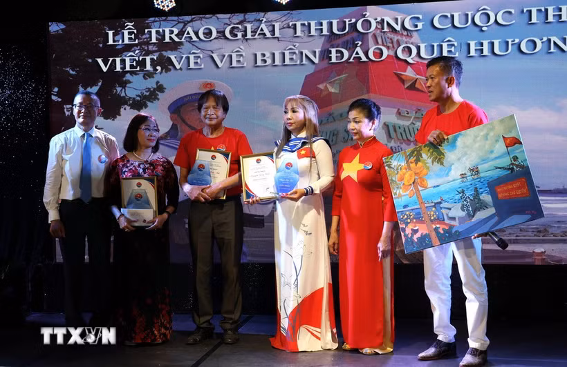 Đại sứ Vũ Quang Minh (ngoài cùng bên trái) trao Giải Nhất cho ba thí sinh dự thi ở các thể loại văn xuôi, thơ và tranh vẽ. (Ảnh: Thu Hằng/TTXVN)