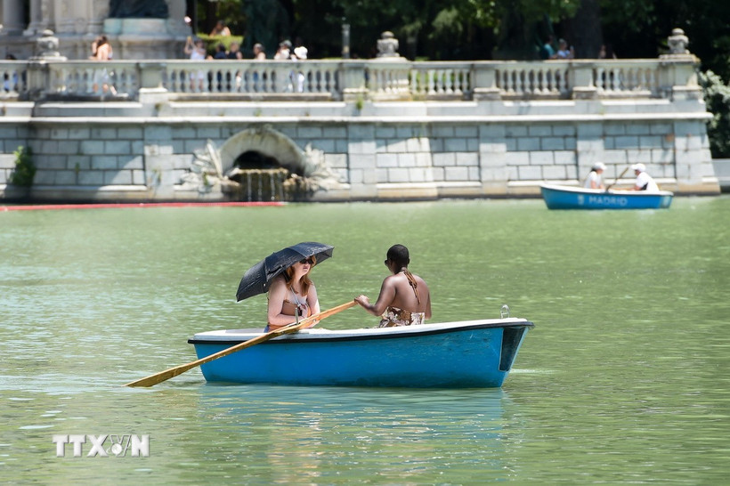 Người dân đi thuyền trên sông trong ngày nắng nóng tại Madrid, Tây Ban Nha. (Ảnh: THX/TTXVN)