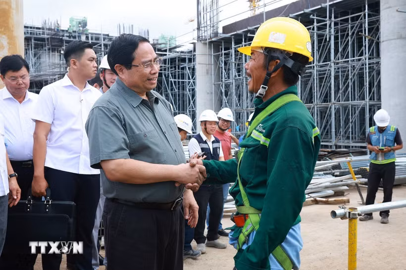 Thủ tướng Phạm Minh Chính với công nhân thi công dự án Cảng Hàng không Quốc tế Phú Quốc. (Ảnh: Dương Giang/TTXVN)