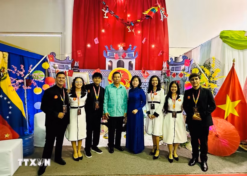 Đại sứ Vũ Trung Mỹ chụp ảnh cùng nhóm sinh viên Venezuela xây dựng Không gian “Việt Nam - Đất nước, Con người”. (Ảnh: TTXVN phát)
