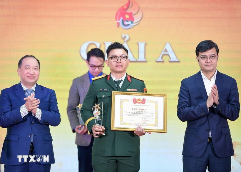 Đồng chí Bùi Quang Huy, Ủy viên dự khuyết Ban Chấp hành Trung ương Đảng, Bí thư thứ nhất Ban Chấp hành Trung ương Đoàn, Trưởng Ban Chỉ đạo 35 Trung ương Đoàn trao giải A cho tác giả. (Ảnh: Minh Đức/TTXVN)