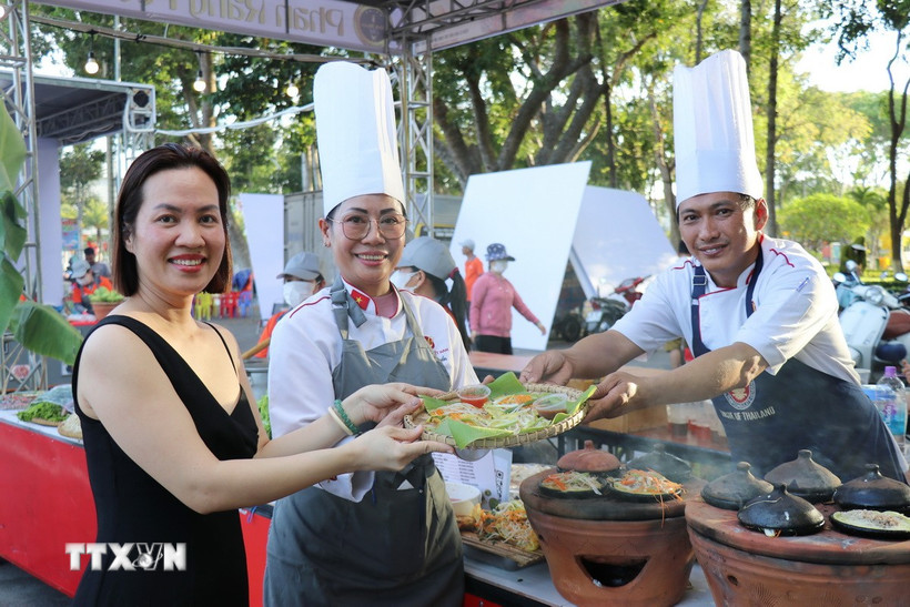 Du khách thích thú trải nghiệm món "bánh xèo ngàn năm" được làm bởi các đầu bếp chuyên nghiệp đến từ Thành phố Hồ Chí Minh. (Ảnh: Nguyễn Thành/TTXVN)