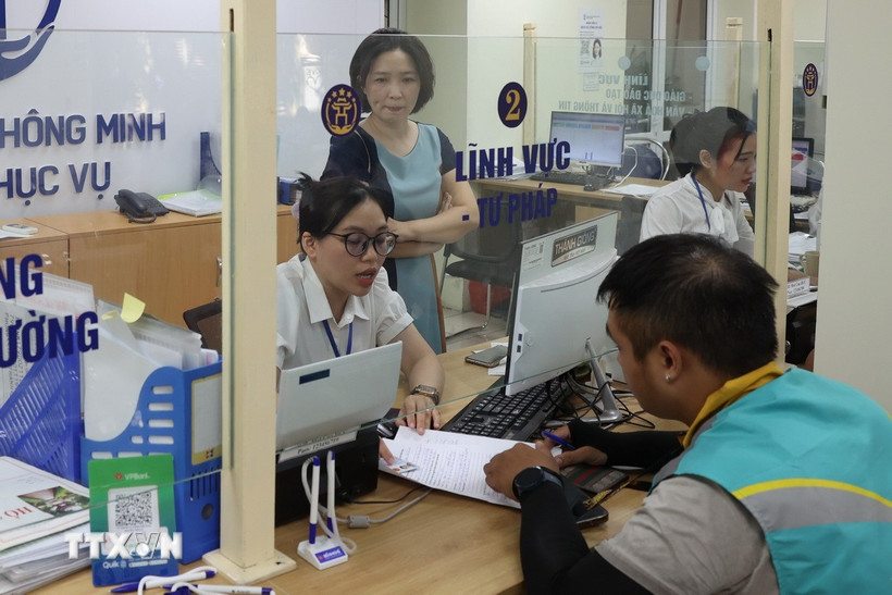 Cán bộ, công chức tận tình giải đáp thắc mắc, hỗ trợ giải quyết hồ sơ cho nhân dân tại Điểm phục vụ Hành chính công Hai Bà Trưng, Hà Nội. (Ảnh: Vũ Quang/TTXVN)