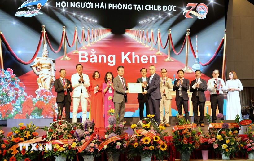 Đại sứ Việt Nam tại Đức Vũ Quang Minh trao Bằng khen của Chủ tịch Ủy ban Nhân dân thành phố Hải Phòng tặng Hội người Hải Phòng tại Đức. (Ảnh: Thanh Tùng/TTXVN)