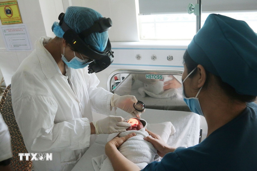 Bé trai M.K.C (78 ngày tuổi, ngụ xã Phú Vinh, tỉnh Đồng Nai) được các bác sỹ kiểm tra biến chứng về thị lực. (Ảnh: Lê Xuân/TTXVN)