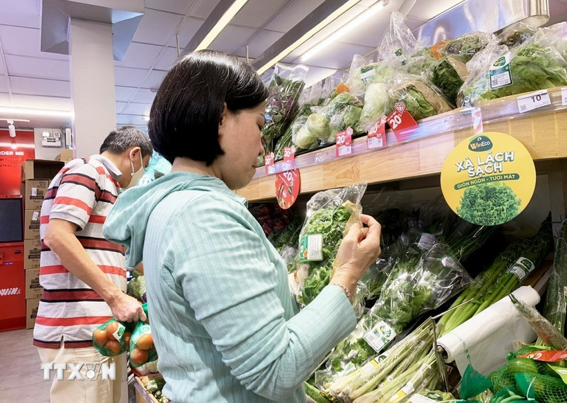 Khách chọn mua sản phẩm “xanh” và “sạch” thân thiện môi trường tại siêu thị WinMart+. (Ảnh: Hồng Đạt/ TTXVN)