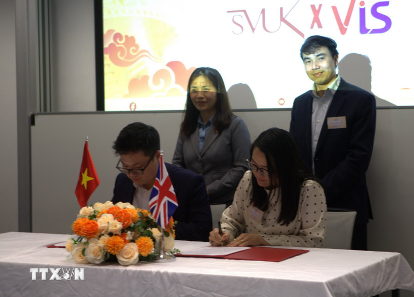 Đại diện Hội Sinh viên Việt Nam tại Vương quốc Anh và Hội Trí thức Việt Nam tại Anh & Ireland (VIS) ký kết bản ghi nhớ hợp tác. (Ảnh: TTXVN phát)