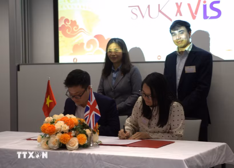 Đại diện Hội Sinh viên Việt Nam tại Vương quốc Anh và Hội Trí thức Việt Nam tại Anh & Ireland (VIS) ký kết bản ghi nhớ hợp tác. (Ảnh: TTXVN phát)