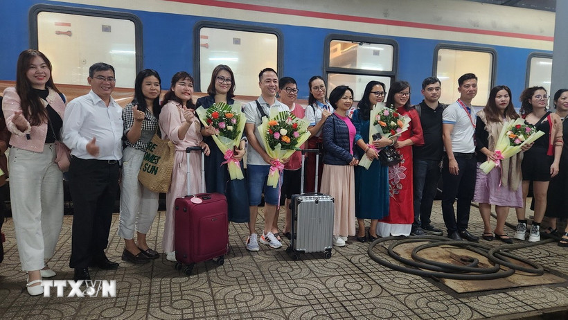 Bà Nguyễn Thị Kim Chung Phó Giám đốc sở Văn hóa Thể thao và Du lịch tỉnh Bình Định tặng hoa cho du khách. (Ảnh: Sỹ Thắng/TTXVN)