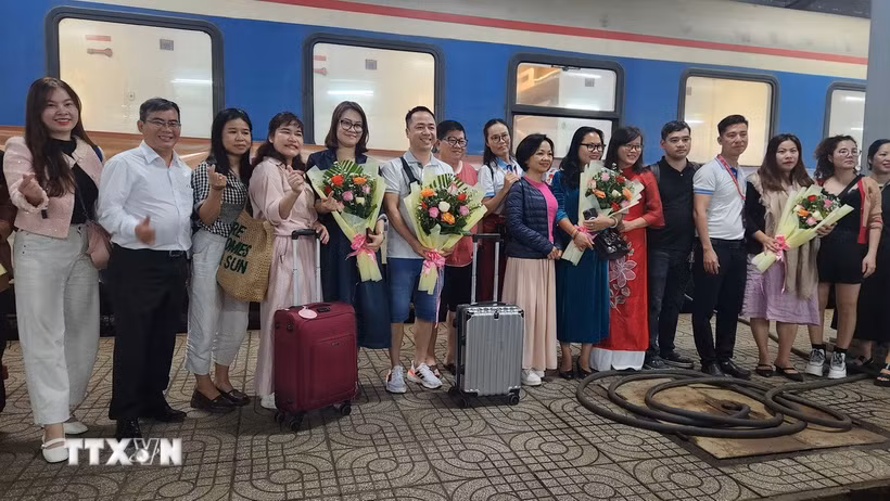 Bà Nguyễn Thị Kim Chung Phó Giám đốc sở Văn hóa Thể thao và Du lịch tỉnh Bình Định tặng hoa cho du khách. (Ảnh: Sỹ Thắng/TTXVN)