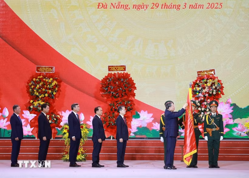 Tổng Bí thư Tô Lâm gắn Huân chương Lao động hạng Nhất lên Cờ truyền thống của Thành phố Đà Nẵng. (Ảnh: Thống Nhất/TTXVN)