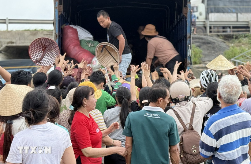 Người dân vùng lũ tỉnh Đắk Lắk nhận hàng cứu trợ. (Ảnh: Tường Quân/TTXVN)