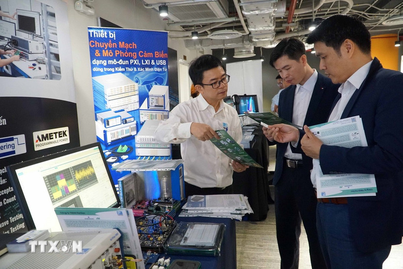 Các đại biểu tham quan triển lãm, giới thiệu các giải pháp phát triển công nghiệp bán dẫn, điện tử. (Ảnh: Thu Hoài/TTXVN)