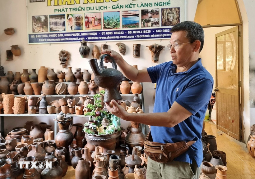 Du khách tìm hiểu sản phẩm gốm tại Hợp tác xã gốm Chăm Bàu Trúc (huyện Ninh Phước, Ninh Thuận). (Ảnh: Nguyễn Thành/TTXVN)