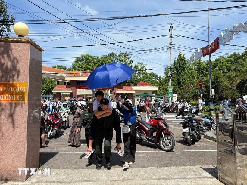 Cán bộ chiến sỹ Trung đoàn cảnh sát cơ động hỗ trợ cõng học sinh bị gãy chân đi thi. (Ảnh: Sỹ Thắng/TTXVN)