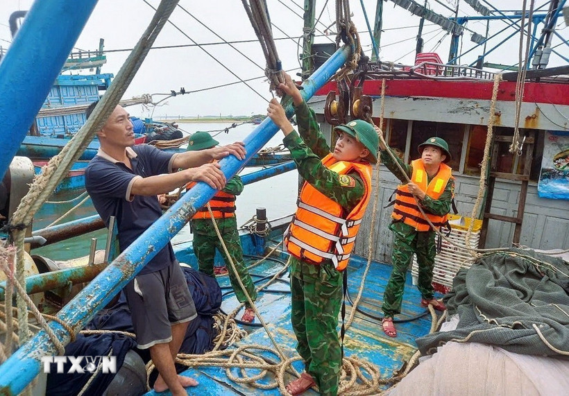 Thêm thẻ Chú thích Lực lượng Đồn Biên phòng Quỳnh Phương (Bộ đội biên phòng tỉnh Nghệ An) hỗ trợ ngư dân chằng buộc trên tàu đánh cá trước cảnh báo bão, ngày 21/7/2025. (Ảnh: TTXVN phát)