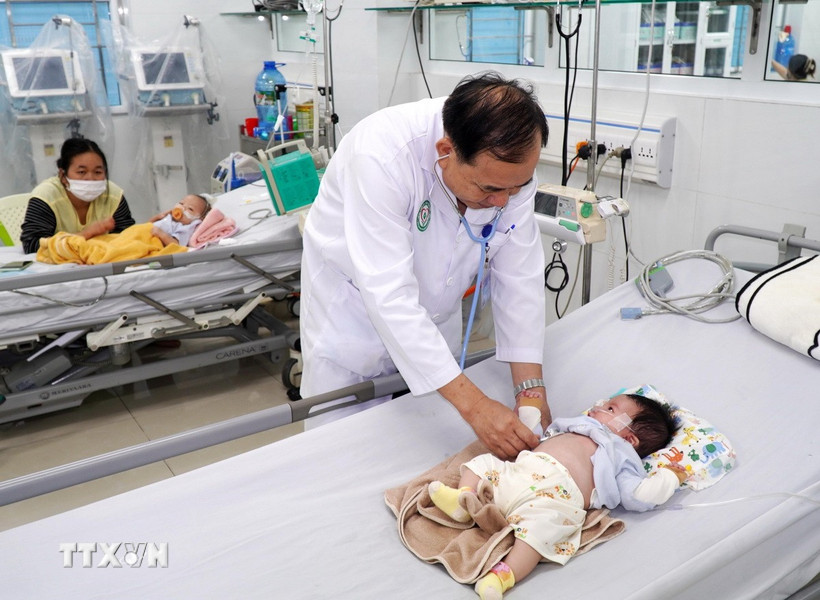 Bác sỹ chuyên khoa 2 Phạm Văn Dũng thăm khám cho bệnh nhi. (Ảnh: Lê Phước Ngọc/TTXVN)