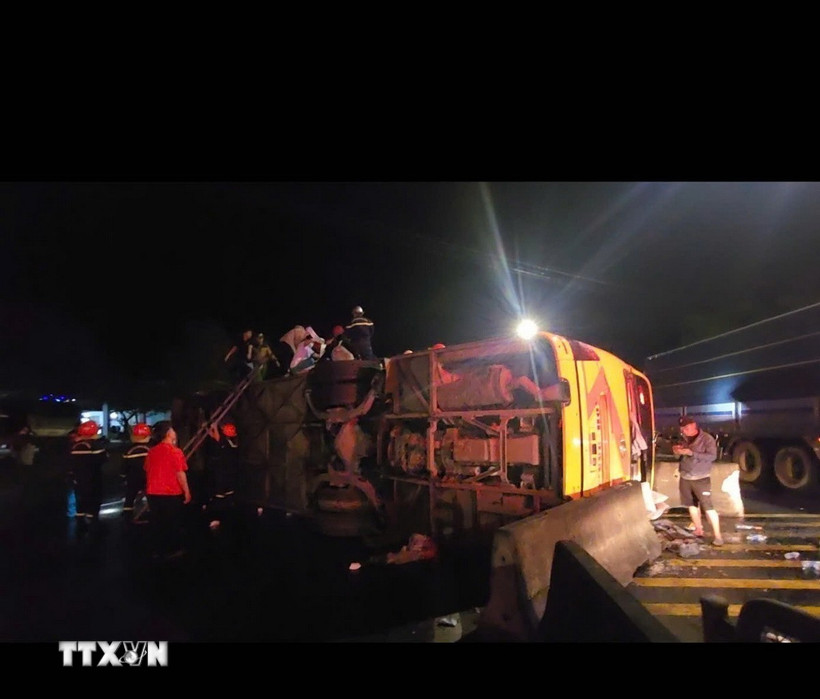 Chiếc xe khách bị lật nghiêng. (Ảnh: TTXVN phát)