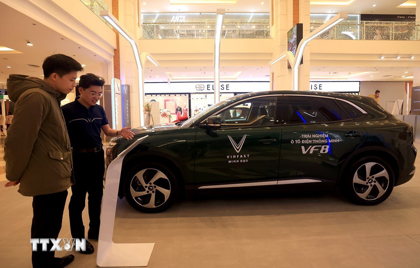 Nhân viên giới thiệu mẫu xe ôtô điện tại một cửa hàng tại Hà Nội. (Ảnh: Tuấn Anh/TTXVN)