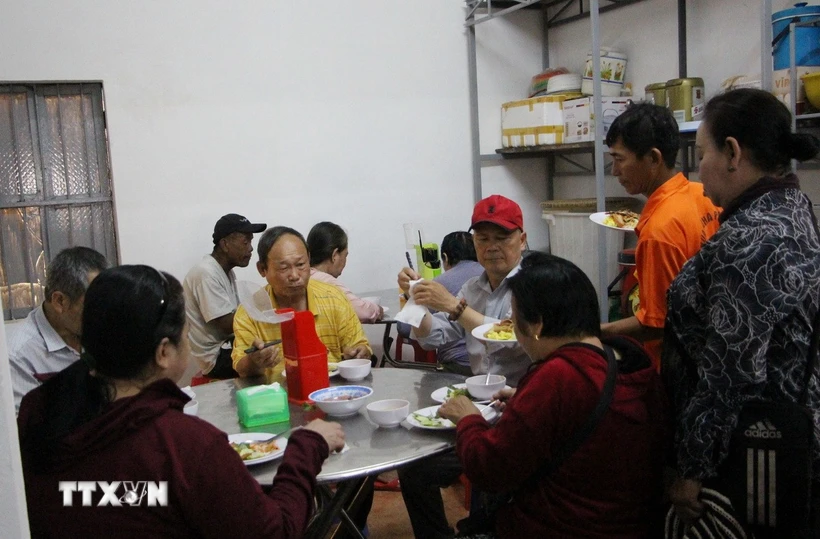 Những người dân đến ăn cơm chay tại chùa Tổ đình Nghĩa Phương. (Ảnh: Phan Sáu/TTXVN)