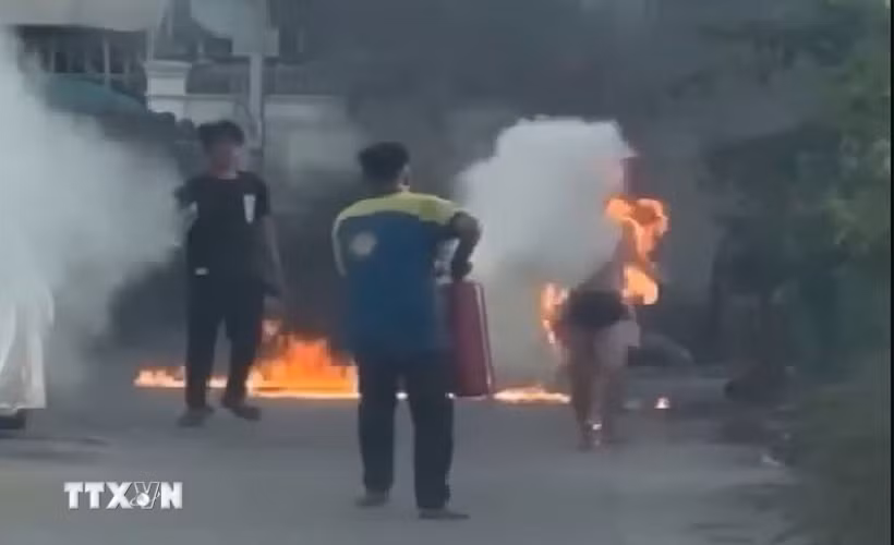 Người dân dùng bình chữa cháy cứu nạn nhân. (Ảnh: TTXVN phát)
