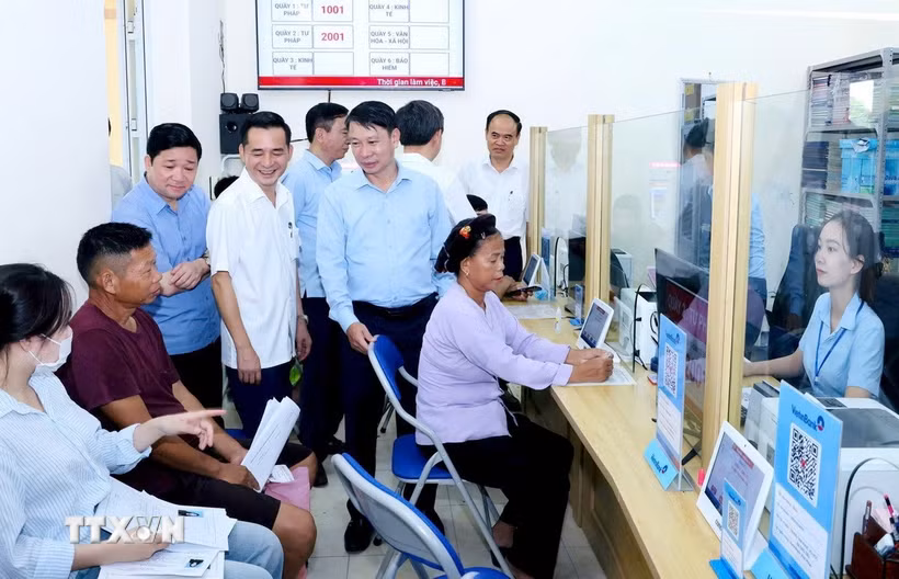 Đoàn công tác tiếp xúc công dân làm thủ tục hành chính tại Trung tâm Phục vụ hành chính công xã Đạo Trù. (Ảnh: PV/TTXVN)