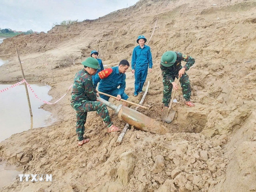 Quả bom được phát hiện bên phải bờ sông Lam (cách cầu Đô Lương hơn 200m) thuộc địa phận xóm Đặng Sơn, xã Đô Lương. (Ảnh: TTXVN phát)