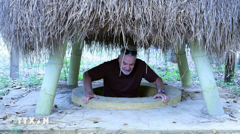 Du khách lên một cửa hầm ngay trong vườn nhà của người dân ở địa đạo Kỳ Anh. (Ảnh: Đỗ Trưởng/TTXVN)