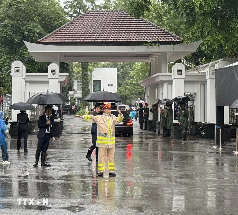 Lực lượng cảnh sát giao thông làm nhiệm vụ điều tiết giao thông trước cửa nhà tang lễ. (Ảnh: Quốc Lũy/TTXVN)