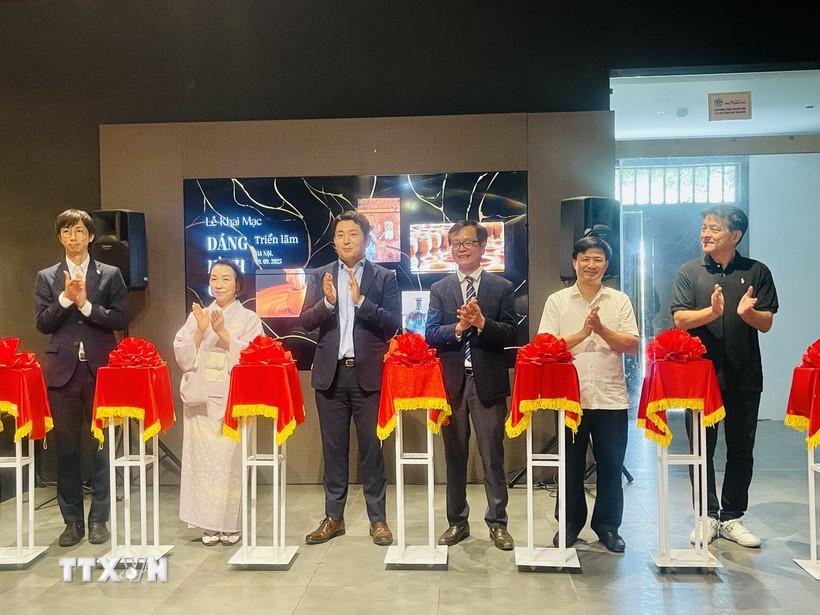 Các đại biểu thực hiện nghi thức cắt băng khai mạc triển lãm “Dáng hình của đất”. (Ảnh: Tuyết Mai/TTXVN)