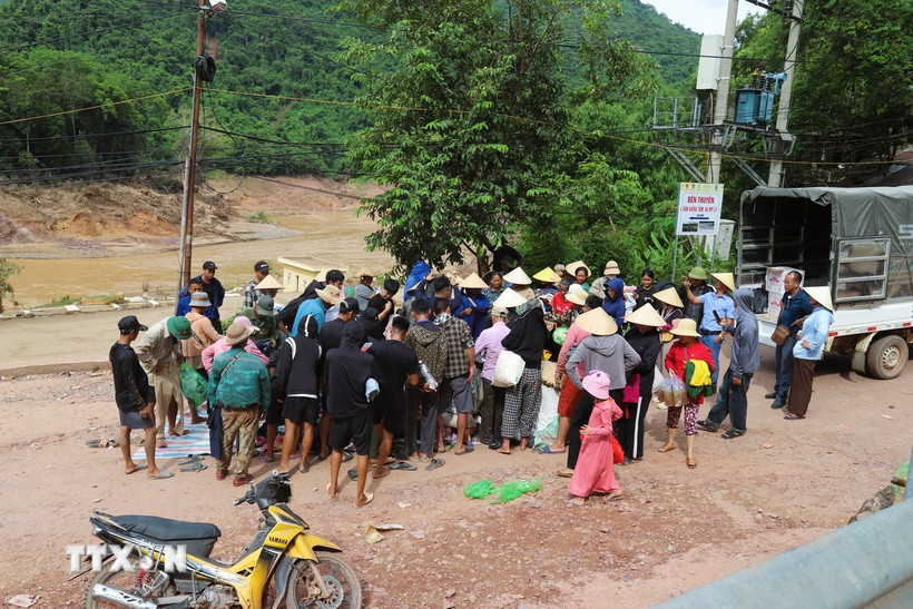 Người dân các bản còn cô lập nhận lương thực, thực phẩm, nhu yếu phẩm từ các hoạt động thiện nguyện tại bản Xiềng Tắm (xã Mỹ Lý, tỉnh Nghệ An) trước khi đưa xuống thuyền để chở về bản làng. (Ảnh: Xuân Tiến/TTXVN)