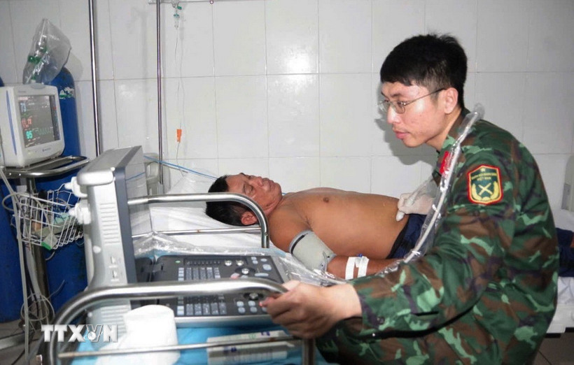 Bác sỹ quân y tiến hành siêu âm ổ bụng cho ngư dân Trần Công Nhanh. (Ảnh: TTXVN phát)