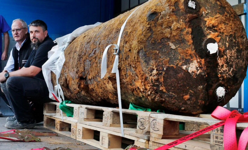 Hai chuyên gia xử lý bom mìn ngồi bên cạnh quả bom nặng 1,8 tấn thời Thế chiến 2, ngay sau khi họ vô hiệu hóa nó, tại Frankfurt, Đức năm 2017. (Nguồn: AP)