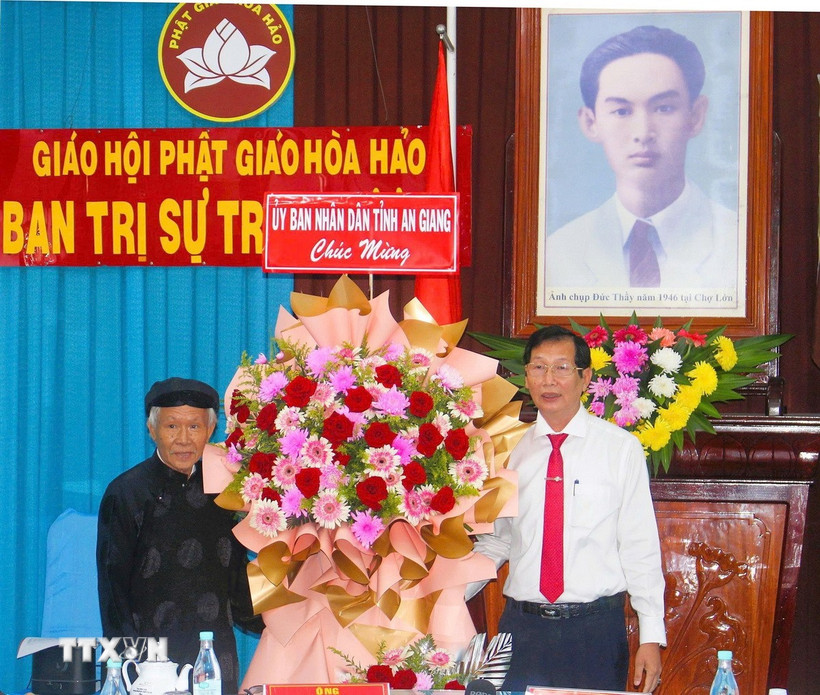 Phó Chủ tịch Ủy ban Nhân dân tỉnh An Giang Lê Văn Phước (phải) tặng hoa mừng Ban Trị sự Trung ương Giáo hội Phật giáo Hòa Hảo. (Ảnh: Công Mạo/TTXVN)