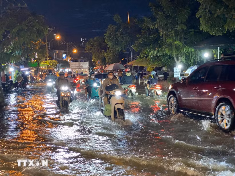 Các phương tiện di chuyển khó khăn khi triều cường gây ngập trên đường Trần Xuân Soạn (Quận 7). (Ảnh: Hồng Giang/TTXVN)