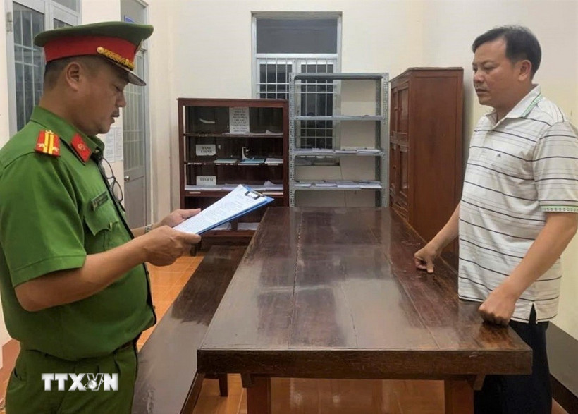 Đại diện Cơ quan Cảnh sát điều tra, Công an tỉnh Cà Mau đọc lệnh khởi tố và bắt tạm giam bị can Nguyễn Tấn Đạt. (Ảnh: TTXVN phát)