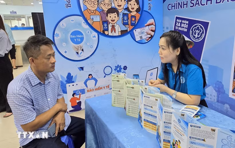 Đại diện Bảo hiểm xã hội thành phố chia sẻ với người dân về những ưu việt của bảo hiểm xã hội. (Ảnh: Minh Thu/TTXVN)