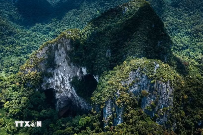 Núi đá vôi karst tại Phong Nha-Kẻ Bàng với các cửa hang lớn mở ra giữa rừng nguyên sinh, phản ánh quá trình kiến tạo địa chất kéo dài hàng triệu năm. (Ảnh: Kha Phạm/TTXVN)