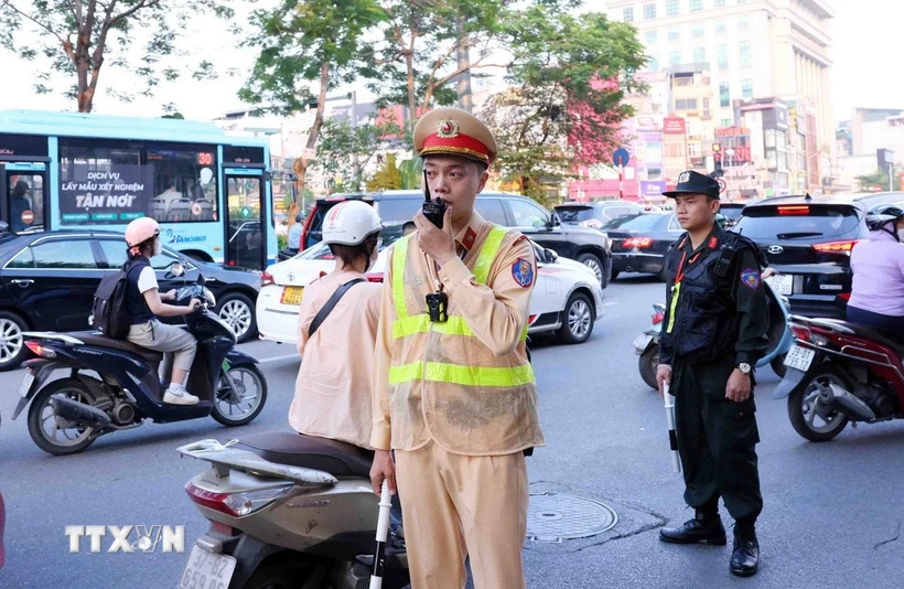 Tổ công tác đặc biệt của Công an thành phố Hà Nội gồm lực lượng Cảnh sát giao thông, Cảnh sát cơ động phối hợp với Công an địa phương thực hiện kiểm tra và xử lý nghiêm các vi phạm giao thông. (Ảnh: Phạm Kiên/ TTXVN)