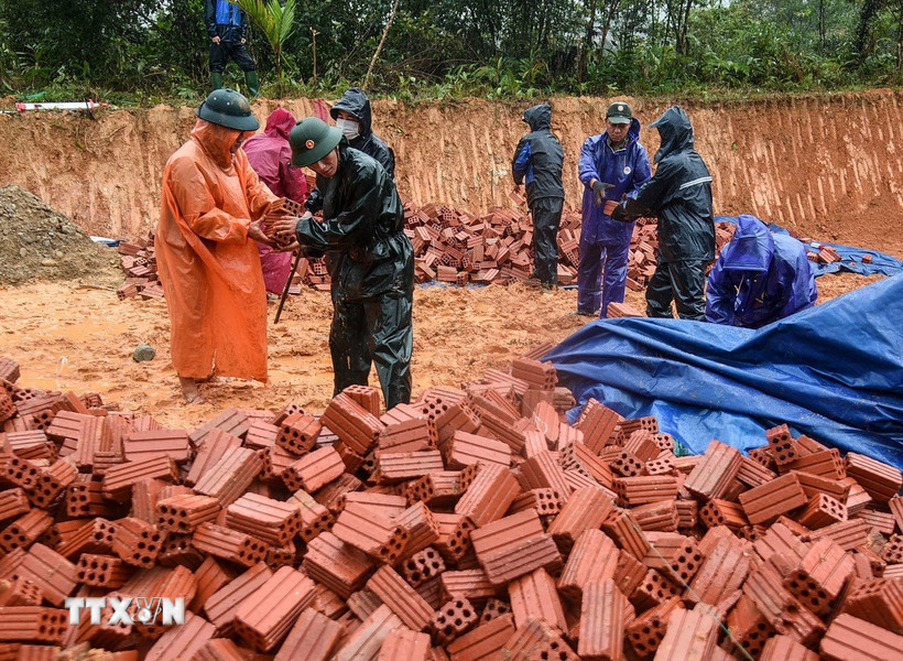 Những người lính bộ đội cụ Hồ quyết tâm “vượt nắng, thắng mưa” xây dựng lại nhà cho người dân vùng sạt lở. (Ảnh: Quốc Dũng/TTXVN)