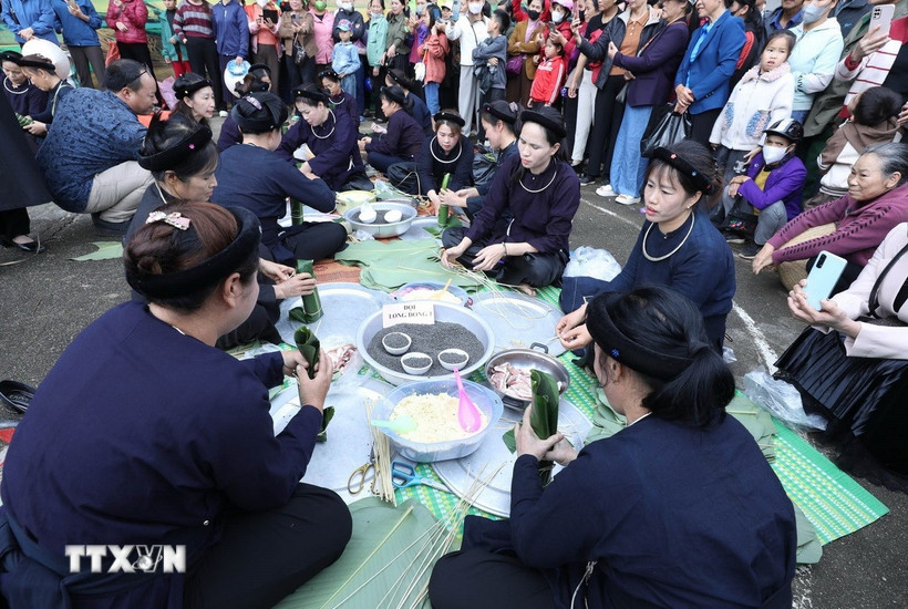 Thi gói bánh chưng đen. (Ảnh: Anh Tuấn/TTXVN)