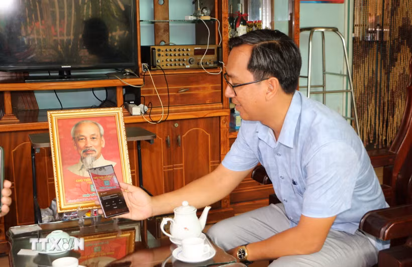 Đồng Tháp: Nhà đảng viên treo ảnh Bác Hồ - nét đẹp văn hóa ở xã Phú Hựu Đảng viên ở Đồng Tháp quét mã QR Code in dưới ảnh Bác Hồ để tìm hiểu những thông tin, câu chuyện kể về Bác. (Ảnh: Nhựt An/TTXVN)